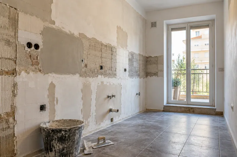 Visualización conceptual IA: Cocina sin muebles con paredes en preparación y zonas de enlucido.